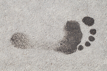 Wet footprint of human barefoot foot on asphalt, top view