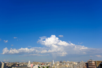 夏の昼間の空。真っ青な空に浮かぶ夏雲。神戸市内の高層ビル１５階より撮影