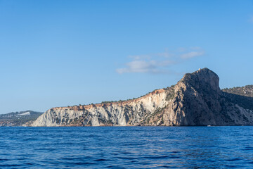 A rock perched over the blue sea of Ibiza