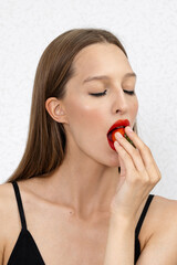 Photo of seductive female holding red strawberry