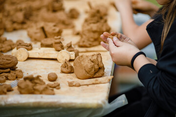 Childrens lesson for modeling from Natural terracotta clay piece held in hands. Wet clay material...
