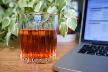 copo de drink com computador ao fundo