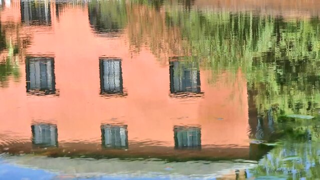 House reflected in duck pond with passing van in Finchingfield, Essex, UK.