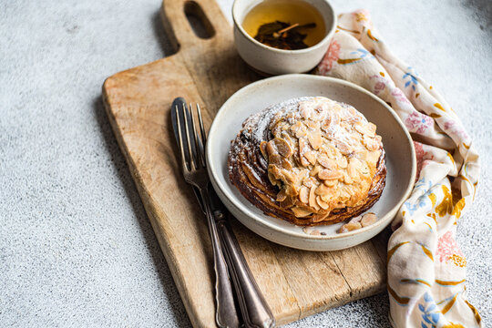 Sweet almond pastry on the plate with cup of green tea