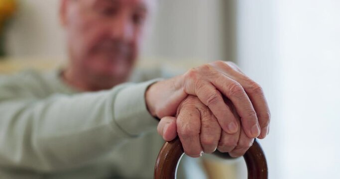 Elderly man, hands and walking stick or wood cane on sofa for balance, support or mobility in retirement or nursing home. Senior patient, closeup and old person with a disability or arthritis aid