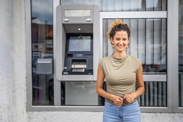 Portrait of adult caucasian woman stand in front of ATM machine