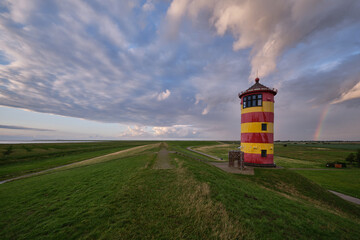 Pilsum lighthouse with dike on the Wadden Sea