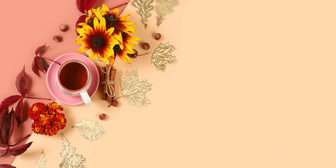 Autumn banner with hot tea in a glass cup, nuts and spices on the background of seasonal flowers...