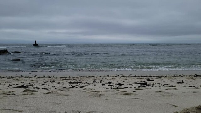 Hyperlapse of powerful waves hitting the sandy Moss Beach, California beach on a cloudy day