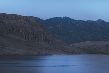 Night landscape in the mountains surrounded by blue sea, beautiful landscape, silhouettes of mountains at dusk