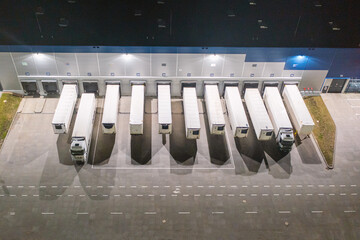 Many trucks and trailers are parked waiting to be loaded and unloaded. transportation of goods, aerial view of the car park