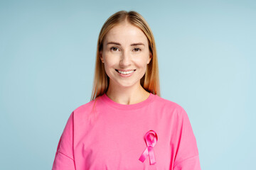Portrait of smiling beautiful woman wearing  t shirts with breast cancer pink ribbon isolated on...