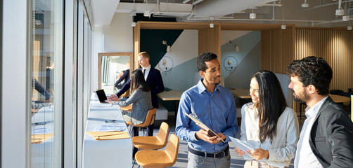 Young happy professional international team business people workers standing in corporate office,...
