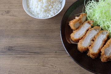 テーブルの上の黒い皿に盛ったトンカツ