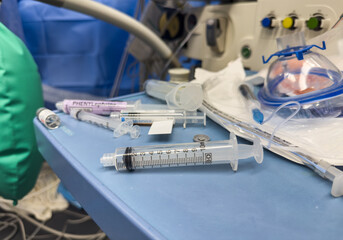 Hospital tools like syringes, drugs, and IV fluids encapsulate healing and peril. They embody...