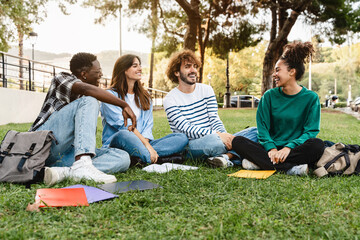 College student friends on the grass, having fun together in the university campus - African...