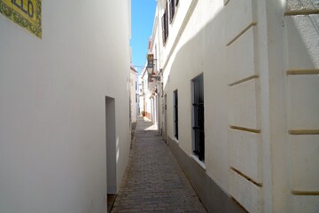 narrow alley in the old town of Tarifa between white houses, Costa de la Luz, Andalusia, province of Cádiz, Spain
