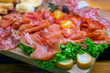 Fresh cuts of French cured sausages, ham, cheeses for party close up