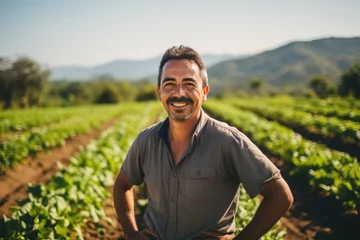 Zelfklevend Fotobehang middle aged male mexican farmer smiling and working on a farm field portrait © NikoG