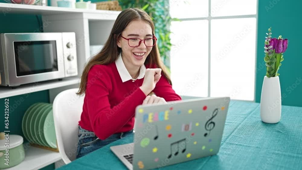 Canvas Prints Young hispanic woman using laptop dancing at dinning room