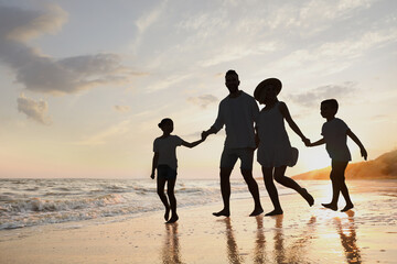 Fototapeta premium Silhouette of family on seashore at sunset
