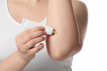 Woman applying ointment from tube onto her elbow on white background, closeup