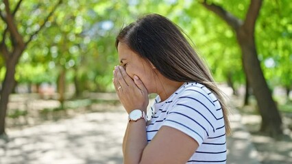 Middle eastern woman sneezing at park