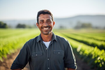 Naklejka na ściany i meble Middle aged latin male farmer working on a farm field smiling portrait