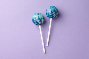 Tasty lollipops on violet background, flat lay