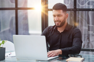 Fototapeta premium Middle-aged man working on laptop in office