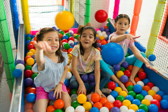 Cheerful children having fun playing in the ball of the playroom