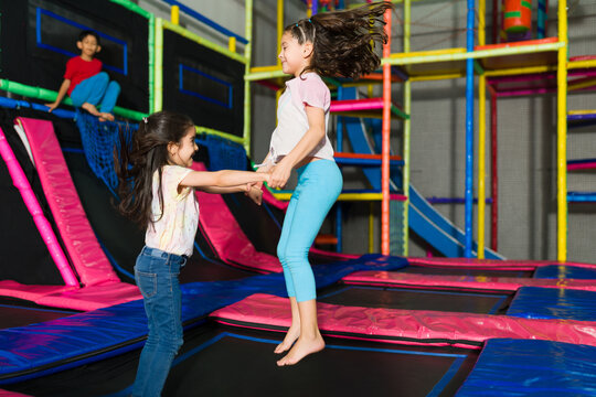 Little girls jumping in the trampoline area of the playroom
