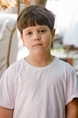 portrait of a boy, portrait of a child, frontal image, boy staring straight ahead, boy in white t-shirt, boy in front