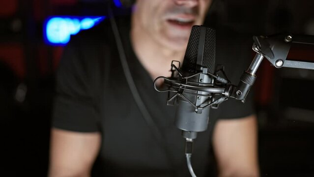 Young hispanic man speaking in a radio show at radio studio