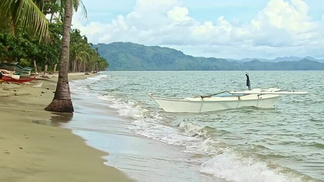 Traditional filipino bangka moored at the beach and tossed around by the monsoon waves in Siocon Zamboanga del Norte Philippines 