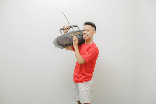 a young man wearing a red shirt on a white background is listening to the radio