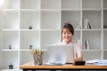 businesswoman working on a laptop computer. Working in the office with laptop concept. Young Asian woman starting a business using a laptop computer