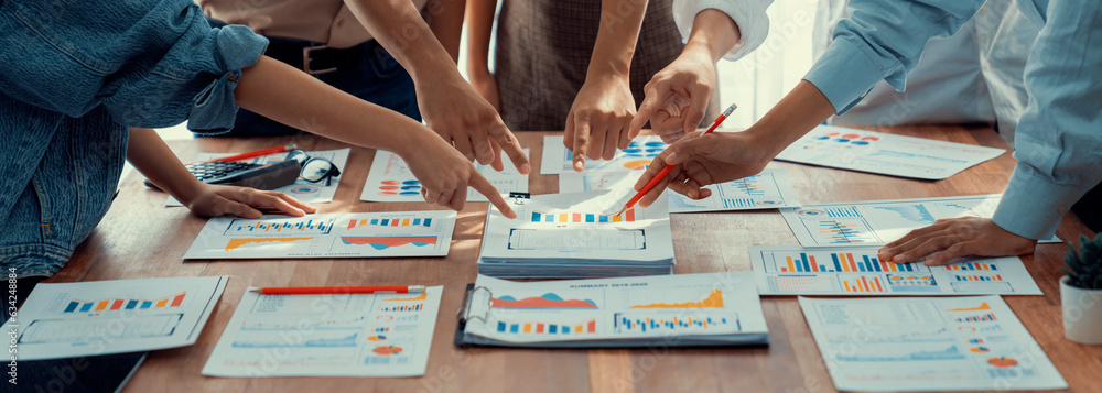 Leinwandbilder Analyst team utilizing BI Fintech to analyze and pointing at financial dashboard paper office. Businesspeople examining report paper on table for business insight. Panorama shot. Scrutinize
