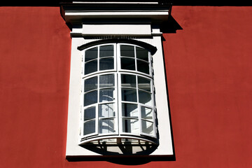 closeup view of old style wood bow window in stucco exterior wall. arched shape with outer operable...