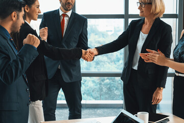 Business people handshake in corporate office showing professional agreement on a financial deal...