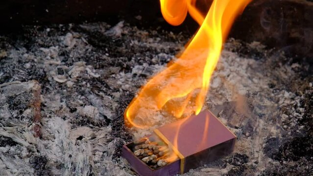 open box of multicolor matches burning in slow motion