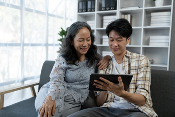 family holidays, hobbies Image of two couples, mother and son doing activities together. Reading books, tablets, talking, giving advice, resting, drinking orange juice to relax in the office in house