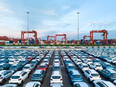 Aerial view new car lined up in the port for import and export business logistic to dealership for sale, Automobile and automotive car parking lot for commercial business industry.