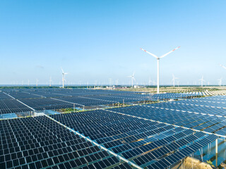solar power panels and wind turbines on beach