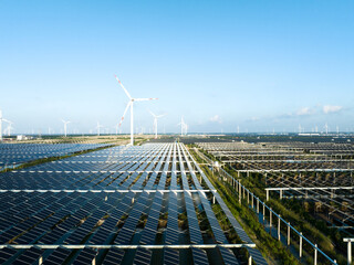 solar power panels and wind turbines on beach