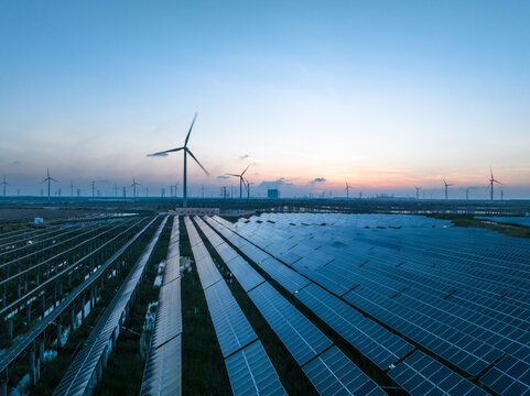 Solar power plant and Windmills aerial view at sunset. Renewable energy. Green tech.