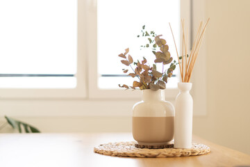 Aroma diffuser in vase on wooden table in living room