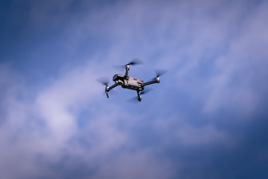 Drone flying in the blue sky with clouds. Flying drone.