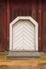 Old white wooden door on a red wall