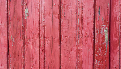 Texture of old battered red vertical boards. Background of pink peeling painted wooden wall. Grunge wallpaper copyspace.